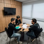 Three people are meeting in a conference room.