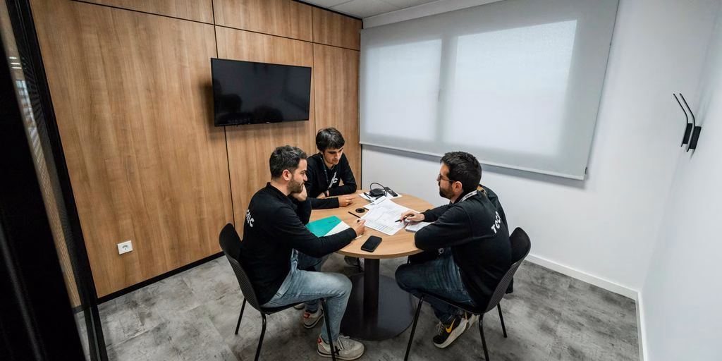 Three people are meeting in a conference room.